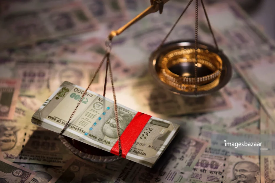 Weighing scale with gold in one pan and cash in another